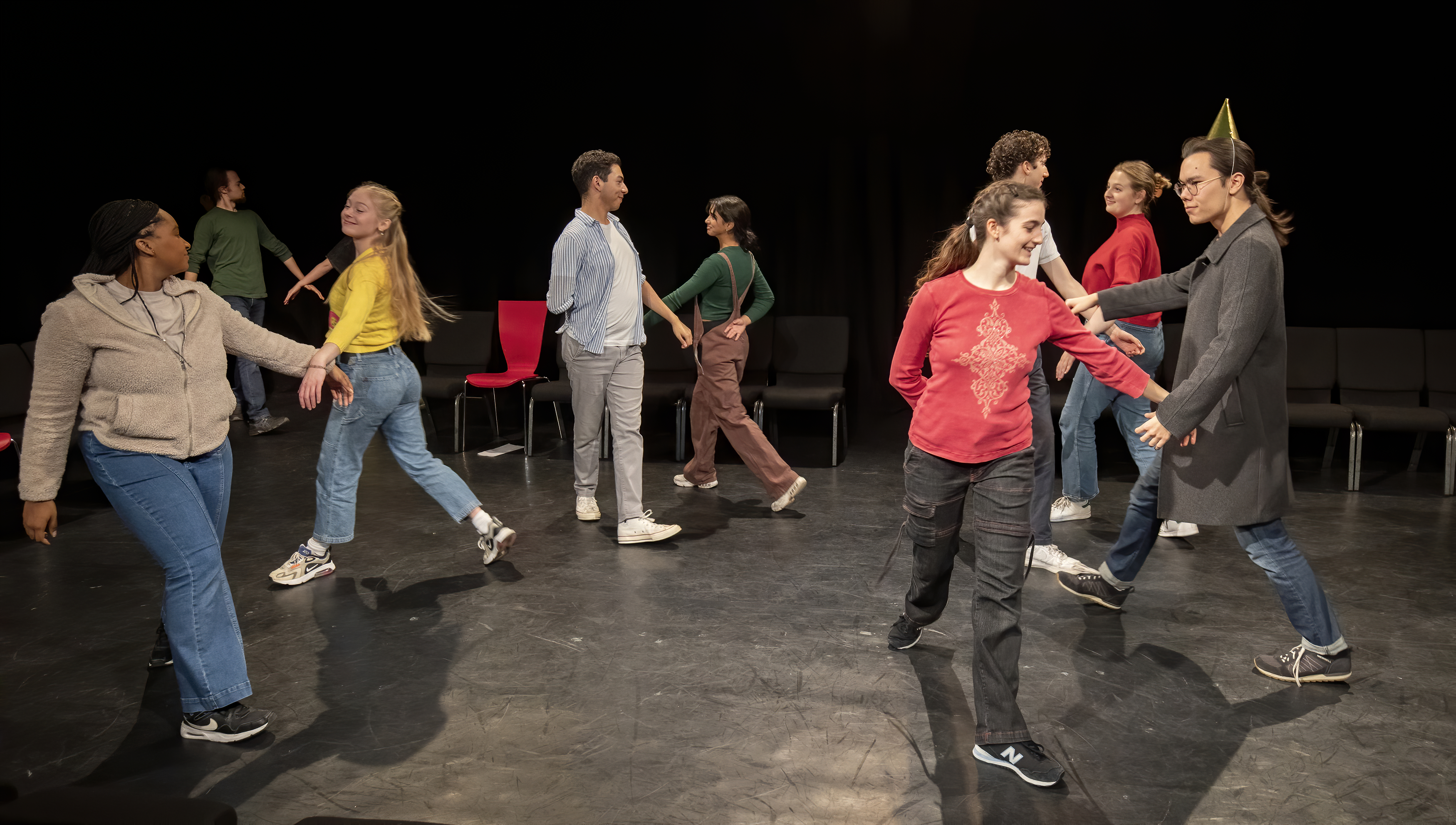 Students moving in mid-performance in a black box theatre